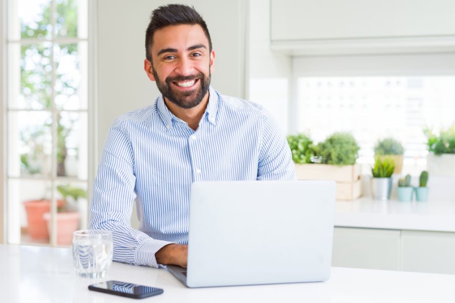 chico sonriente trabajando con portátil