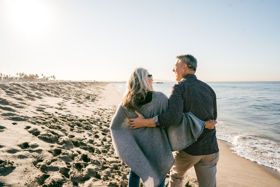 pareja de mediana edad paseando por la arena de la playa