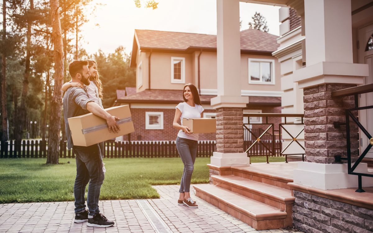 pareja entrando a casa con cajas de mudanza